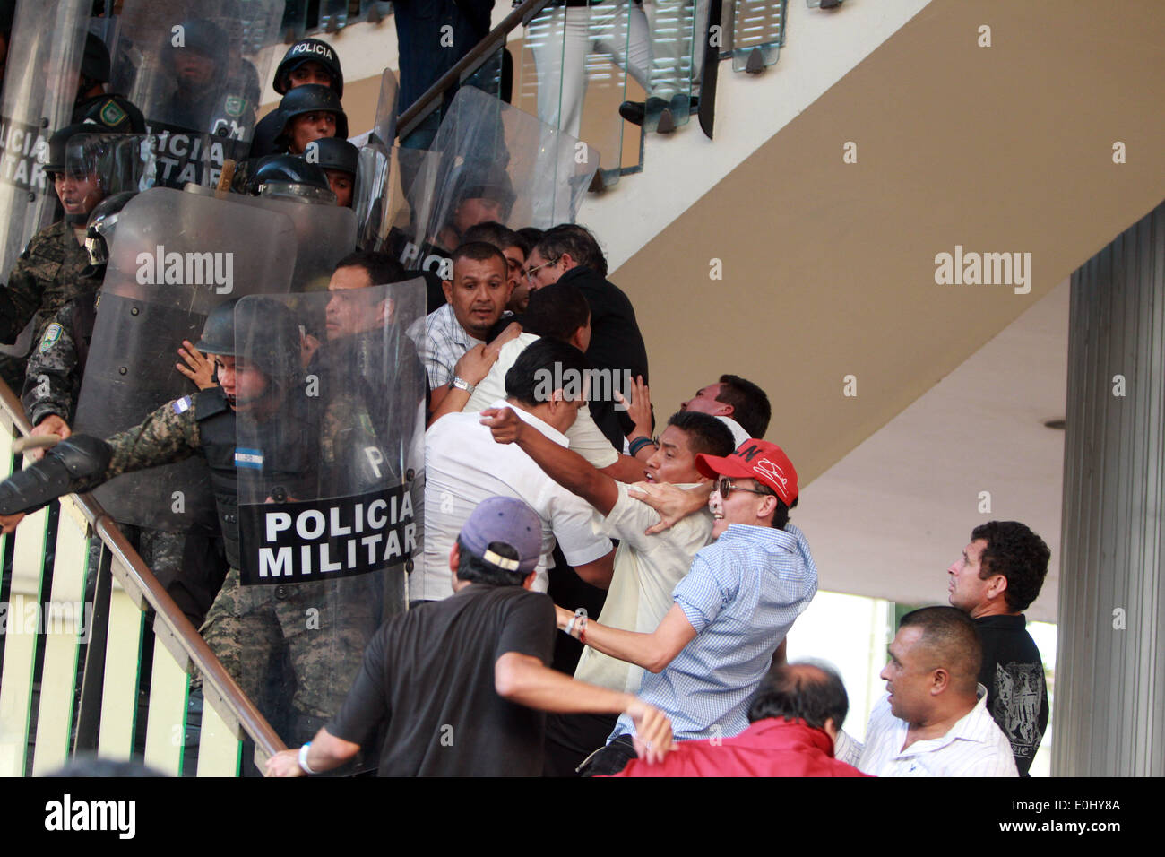 Tegucigalpa, Honduras. 13th May, 2014. Police elements and supporters of the former Honduran President Manuel Zelaya clash in front of the National Congress in Tegucigalpa, Honduras, on May 13, 2014. Followers and deputies of the Liberty and Refoundation Party (Libre, for its acronym in Spanish), the second political force in Honduras, broke in the National Congress on Tuesday, after clashing with police elements that guarded the Legislative Palace. Credit: Rafael Ochoa/Xinhua/Alamy Live News Stock Photo