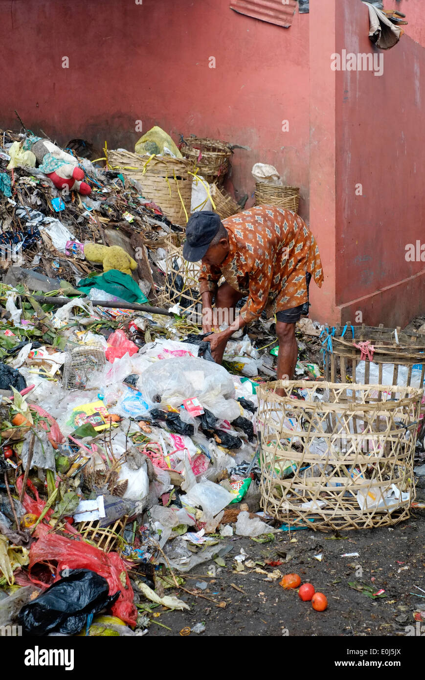 local man working on pile of fetid rubbish at a public dump in malang indonesia Stock Photo