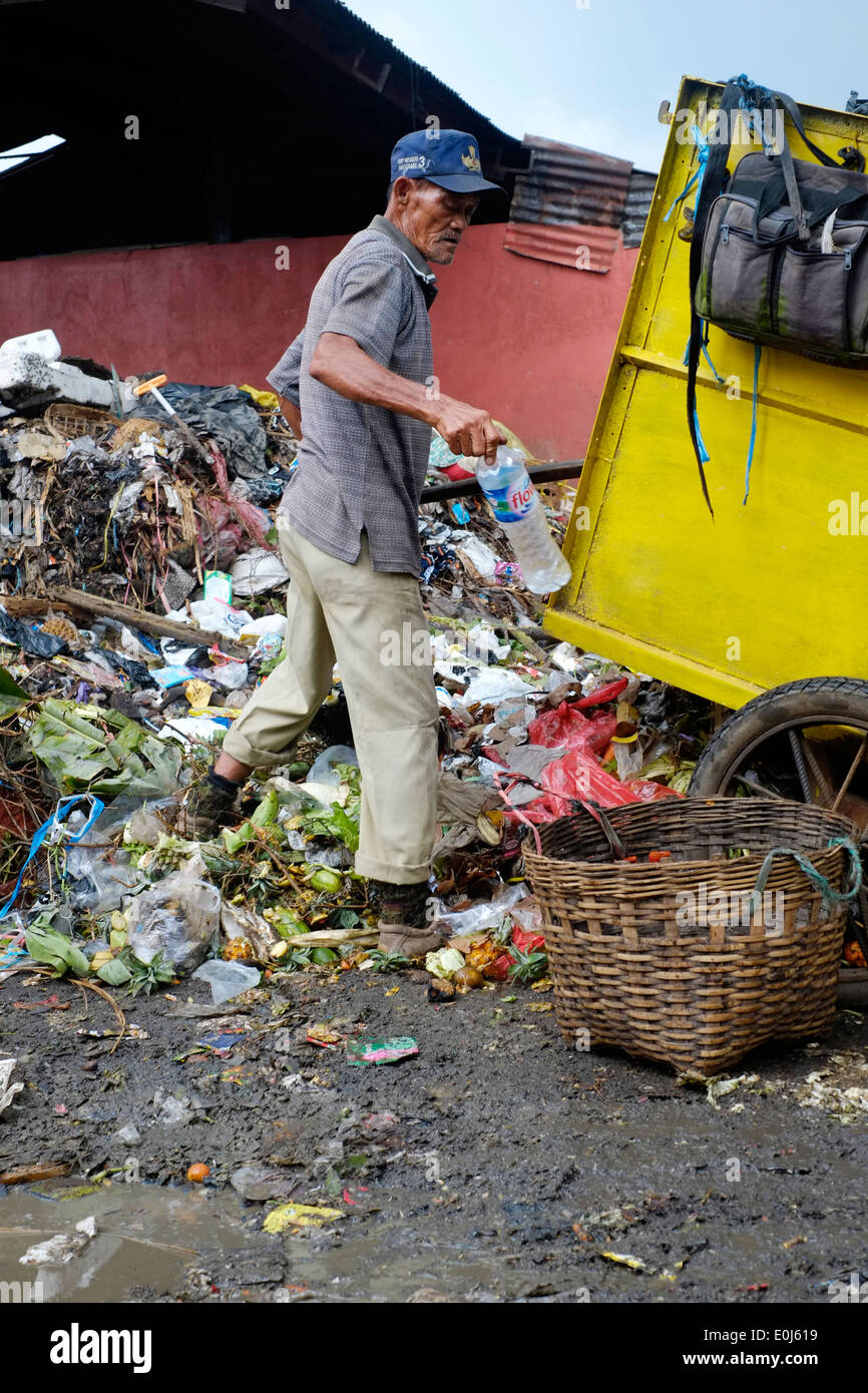 local man working amongst a huge pile of fetid refuse on a public dump in malang java indonesia Stock Photo