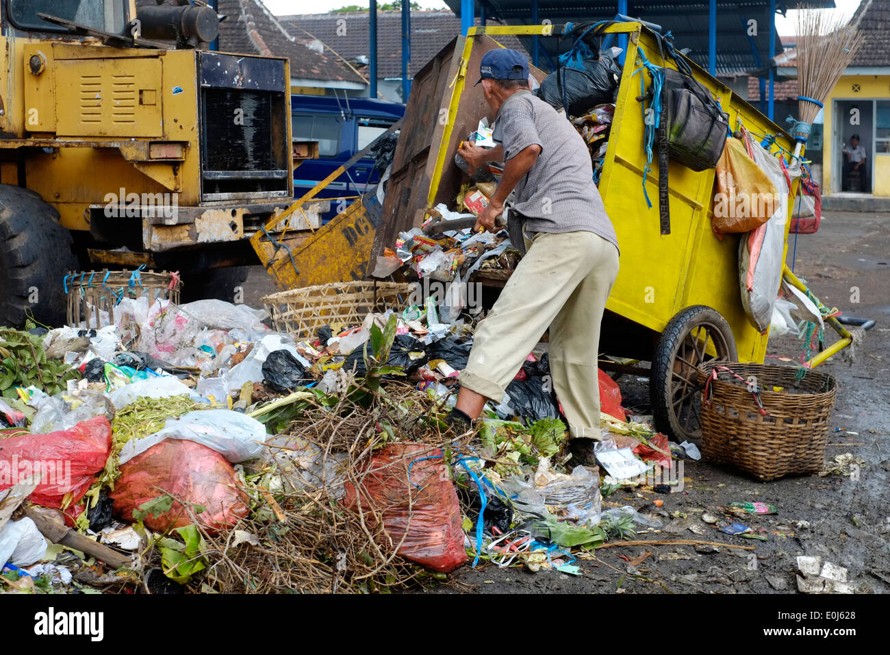 local man working amongst a huge pile of fetid refuse on a public dump in malang java indonesia Stock Photo