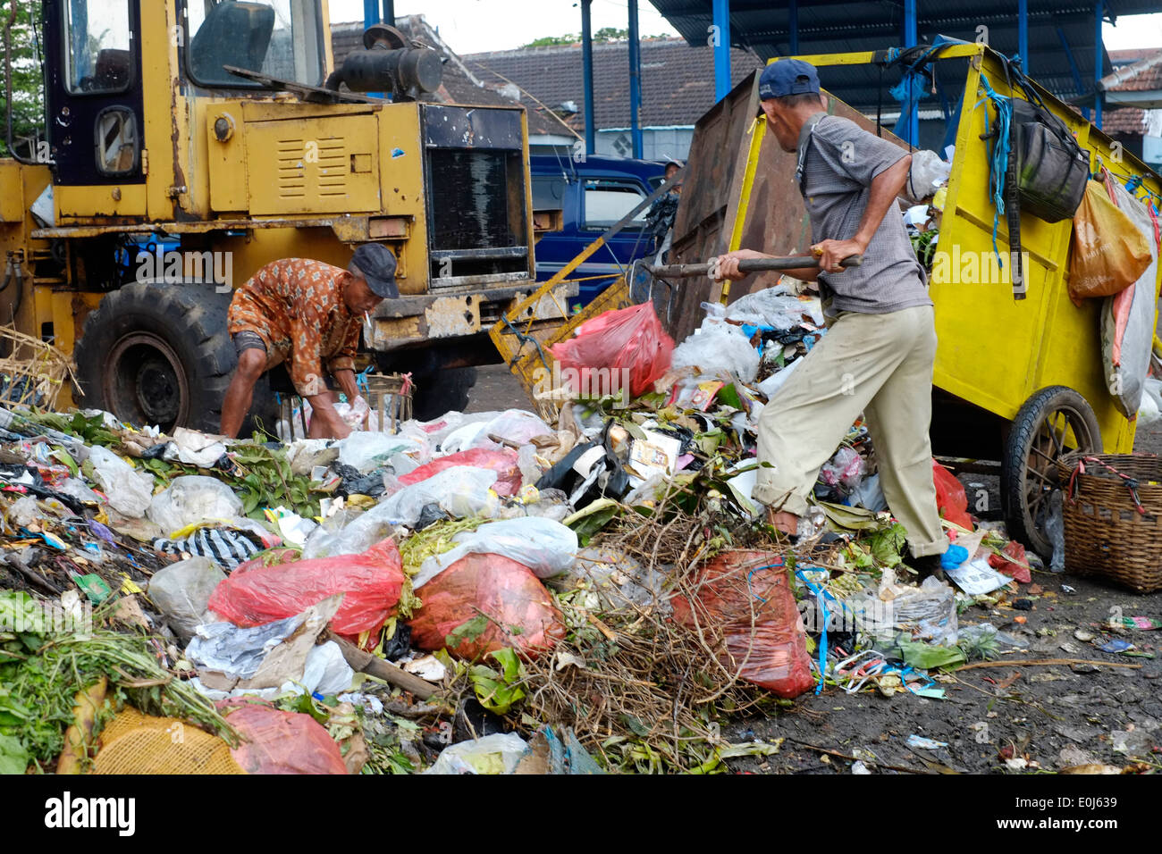 local men working amongst a huge pile of fetid refuse on a public dump in malang java indonesia Stock Photo