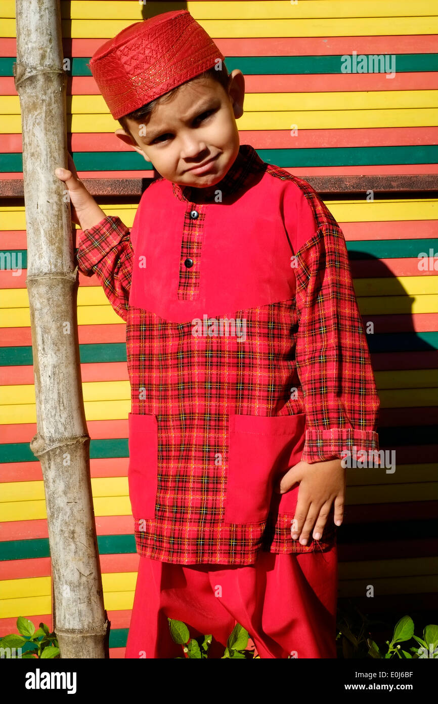 little indonesian schoolboy proudly posing in his school uniform in a small rural village in java Stock Photo