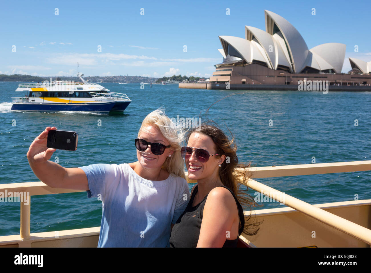 Sydney Australia,Sydney Ferries,Harbour,harbor,Opera House,ferry,upper deck,riders,passenger passengers rider riders,woman female women,friends,posing Stock Photo