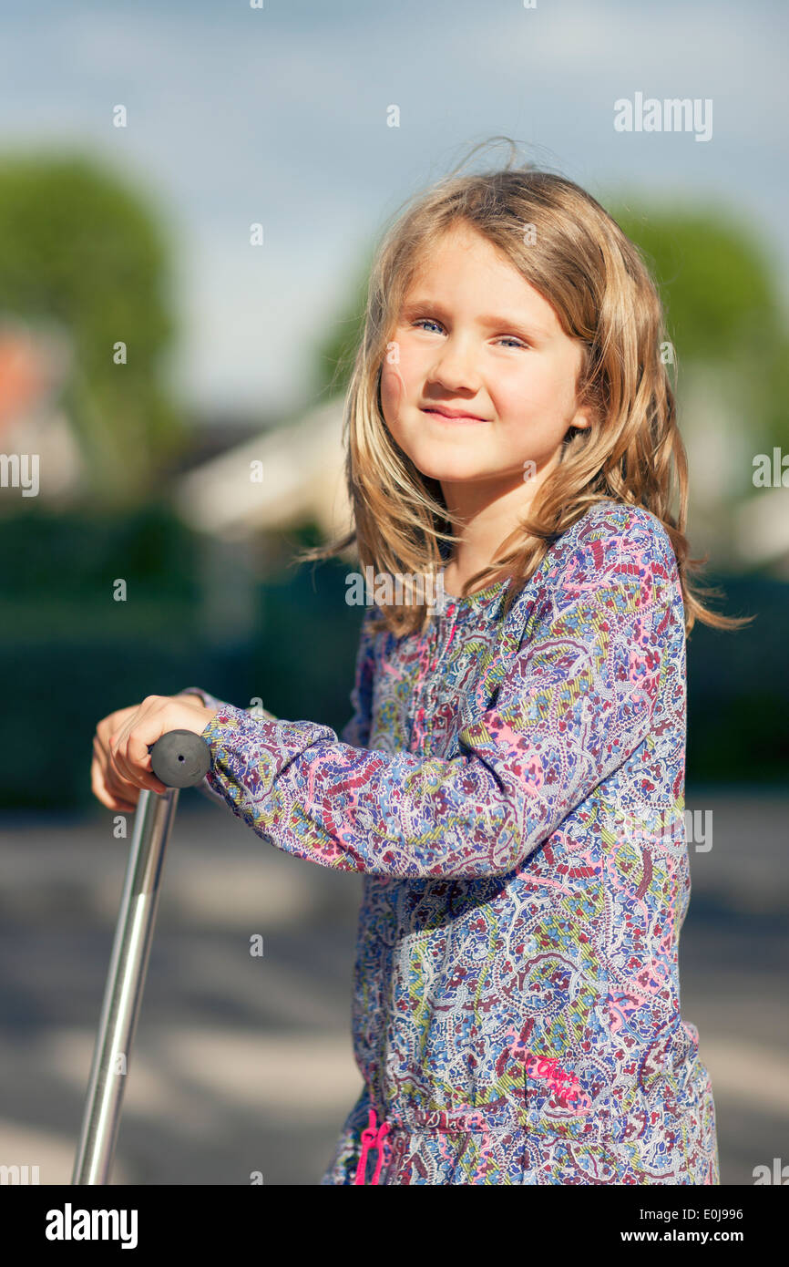 Little girl ride the scooter in the park Stock Photo