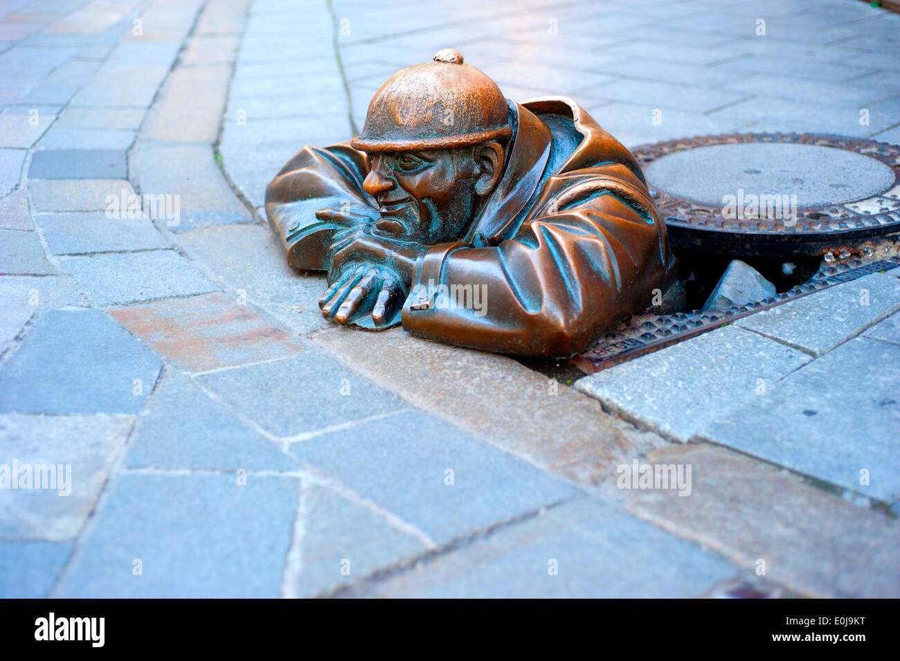 Cumil - statue of man peeking out from under a manhole cover . Popular attraction was made in 1997 Stock Photo