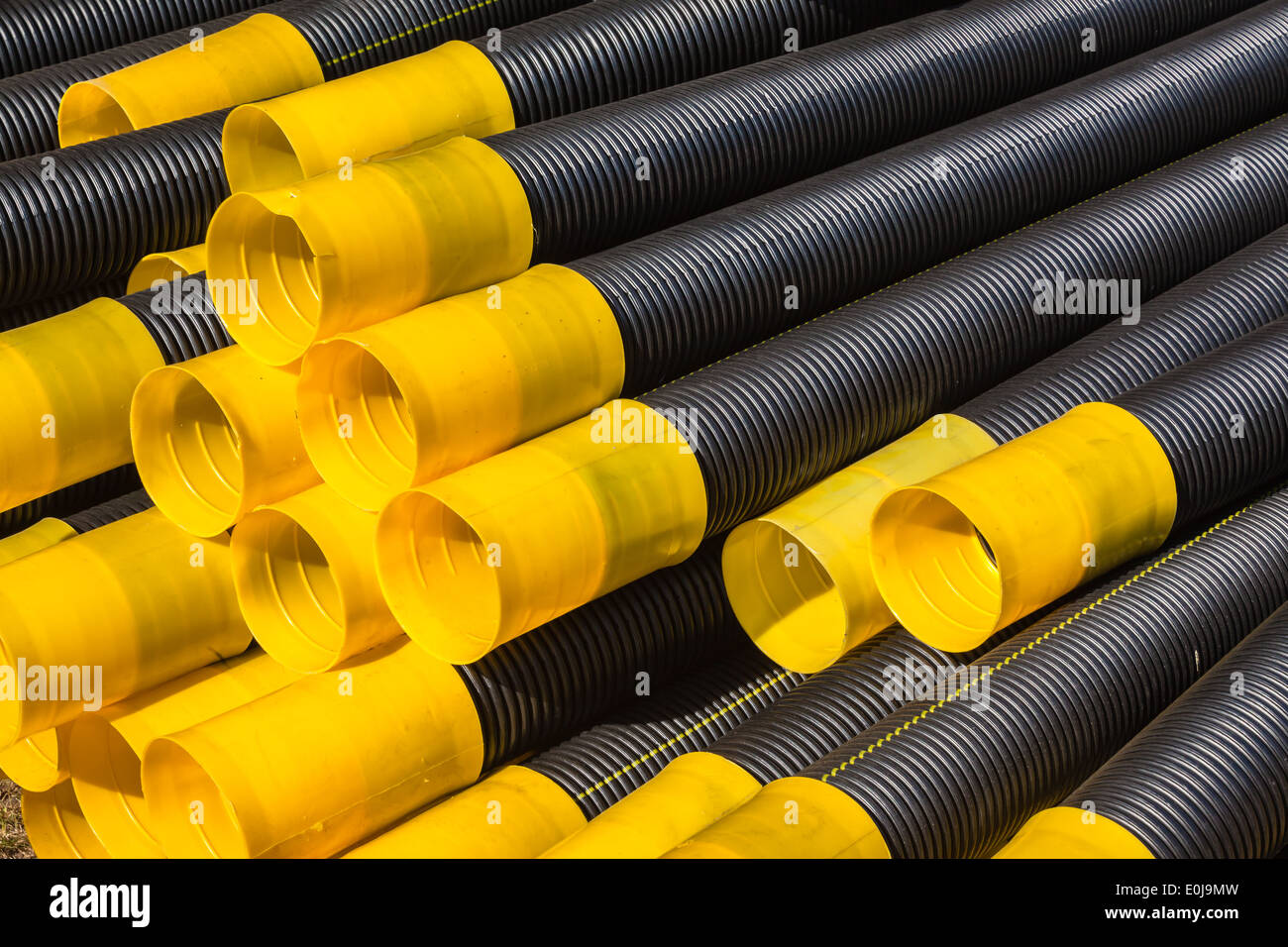 Drainage pipes stacked plastic black yellow stacked together for plumbing construction Stock Photo