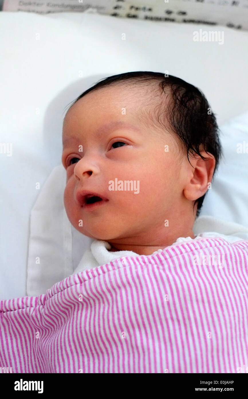 newborn baby a few hours old laying in hospital cot in malang indonesia Stock Photo