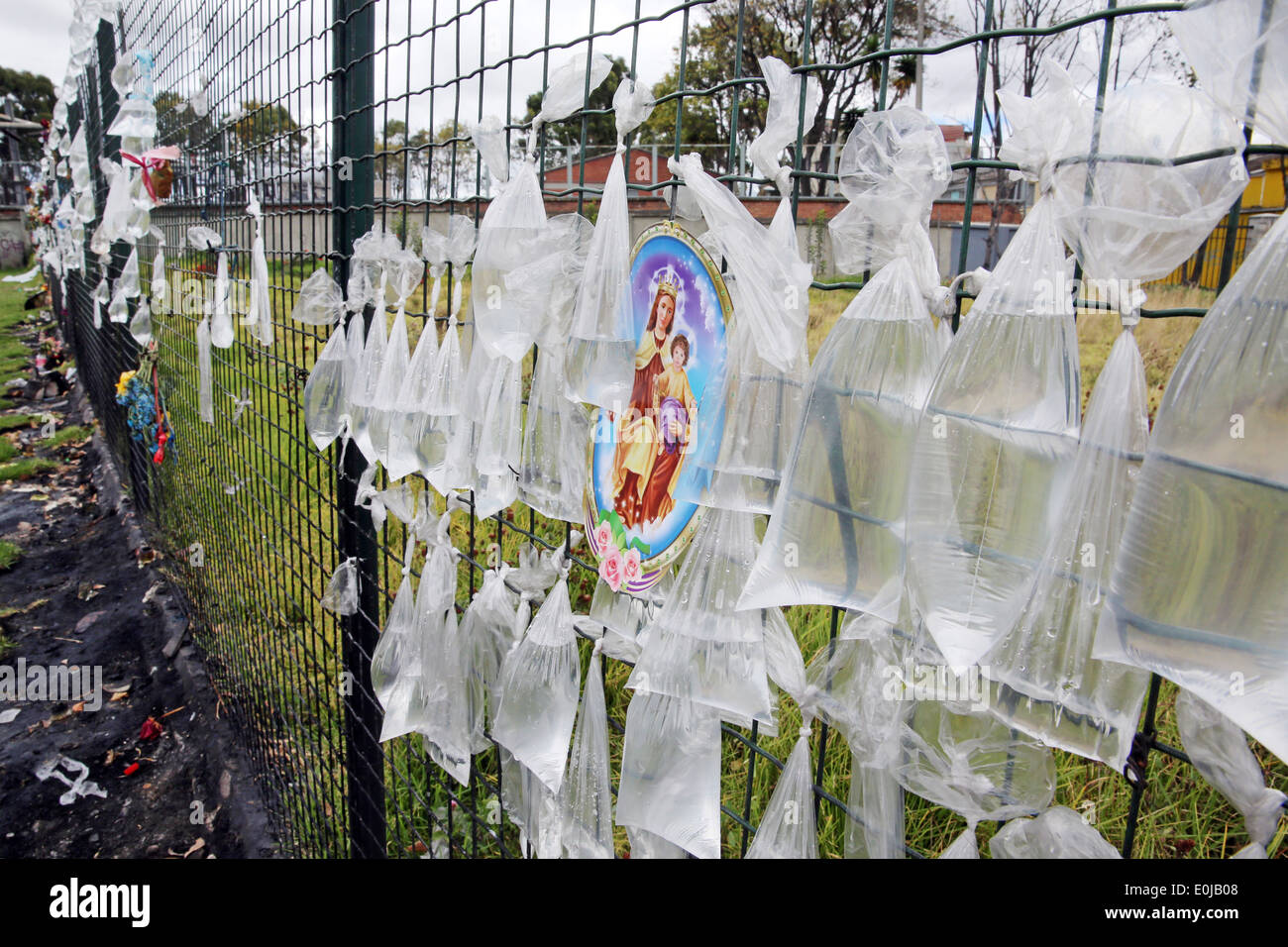 Tansparent plastic bags with water on a fence of the churchyard of nameless dead persons. Bogota, Colombia, South America Stock Photo