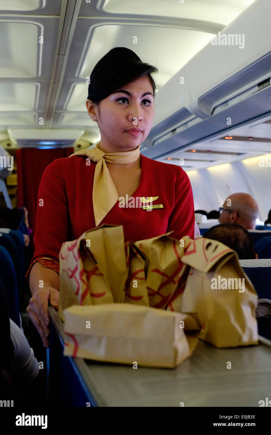 air hostess at work on board a sriwijaya air domestic flight en route from malang to jakarta java indonesia Stock Photo