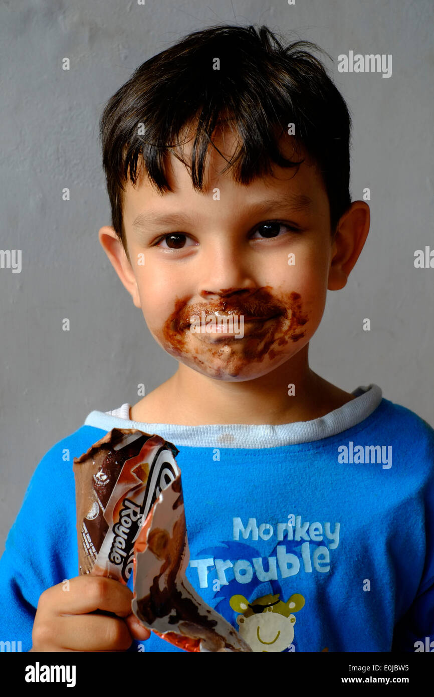 Young boy enjoying licking chocolate hires stock photography and