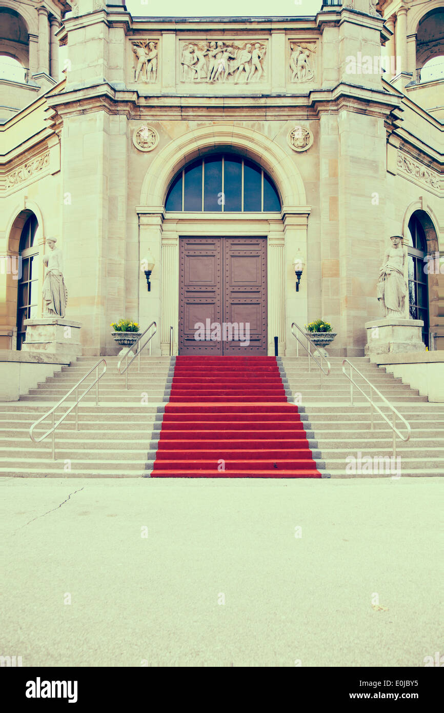 iron doors and red carpet entrance with stone archway Stock Photo