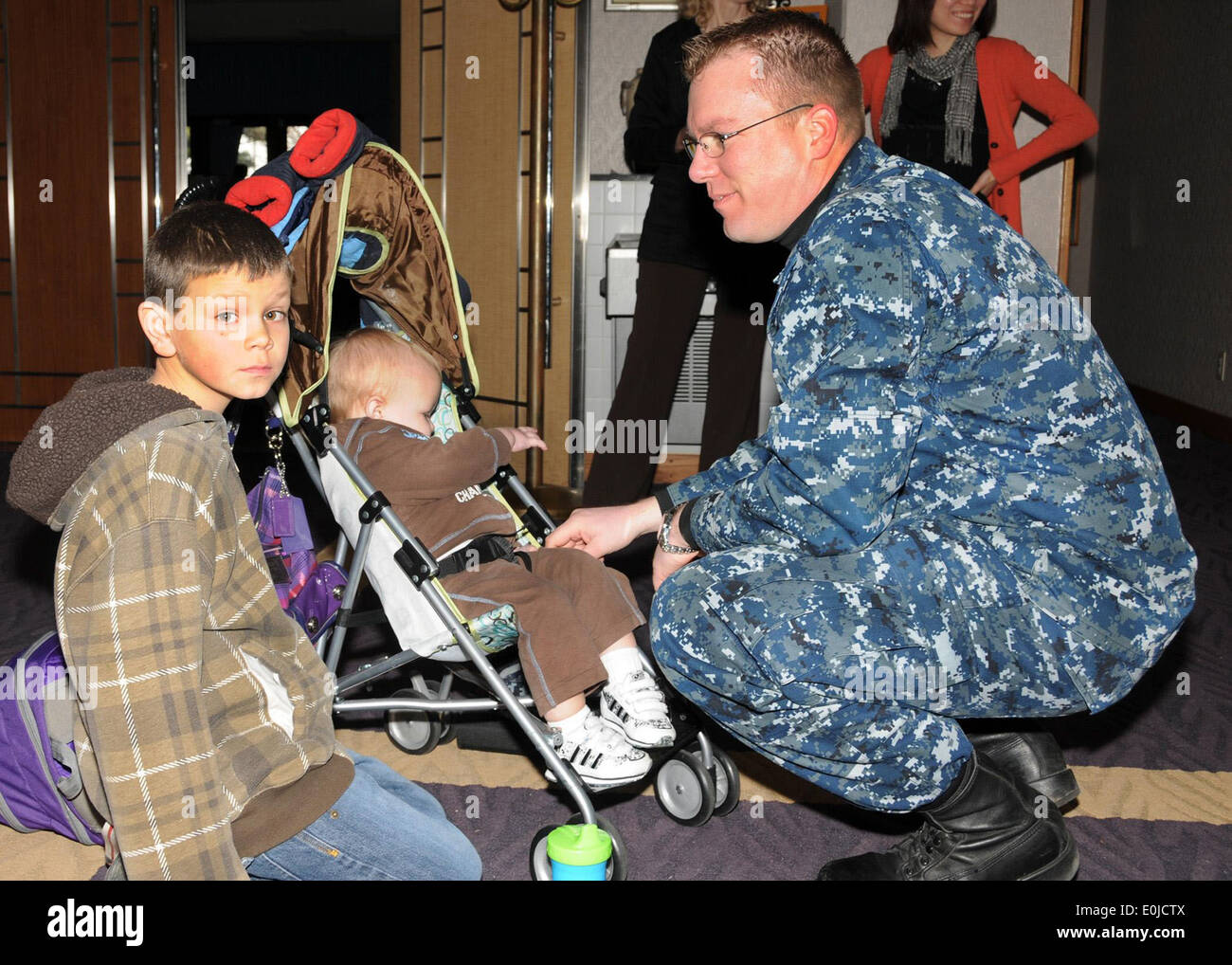 Chief Petty Officer Jascha Janssen, a Navy counselor attached to Commander Task Force 72 comforts his sons Nathan, 9, and Lars, Stock Photo