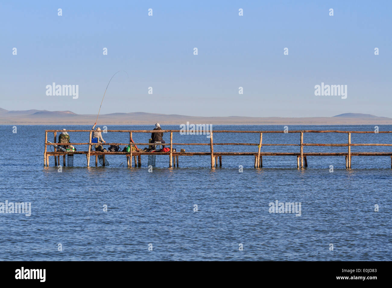 Tree men fishing at Dalai Lake in China Stock Photo