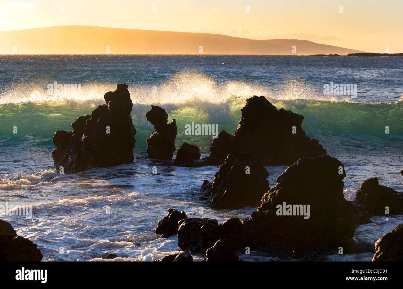 Surf breaks on lava rocks at La Perouse Bay with Kaho' Olawe Island in background from Maui, Hawaii Stock Photo