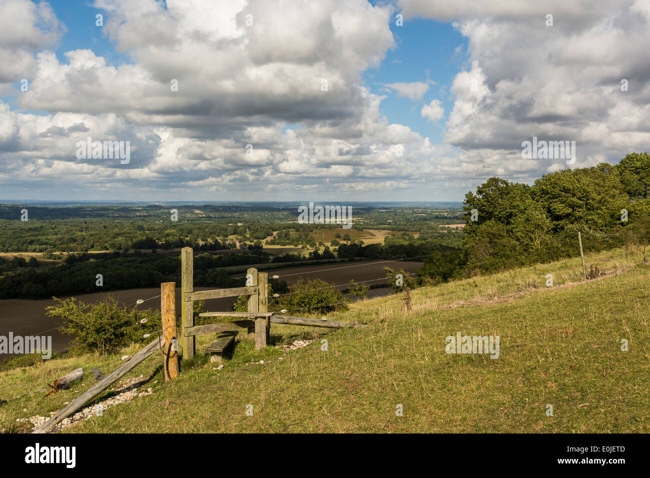 A footpath stile high up on the South Downs in West Sussex with Parham Estate and the Sussex Weald in the background. Stock Photo