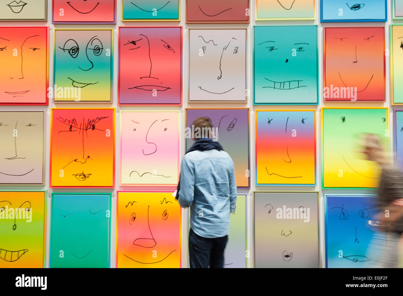 Visitors of the Art Basel 2013 in Basel, Switzerland, pass by a series of paintings by Rob Pruitt. Stock Photo