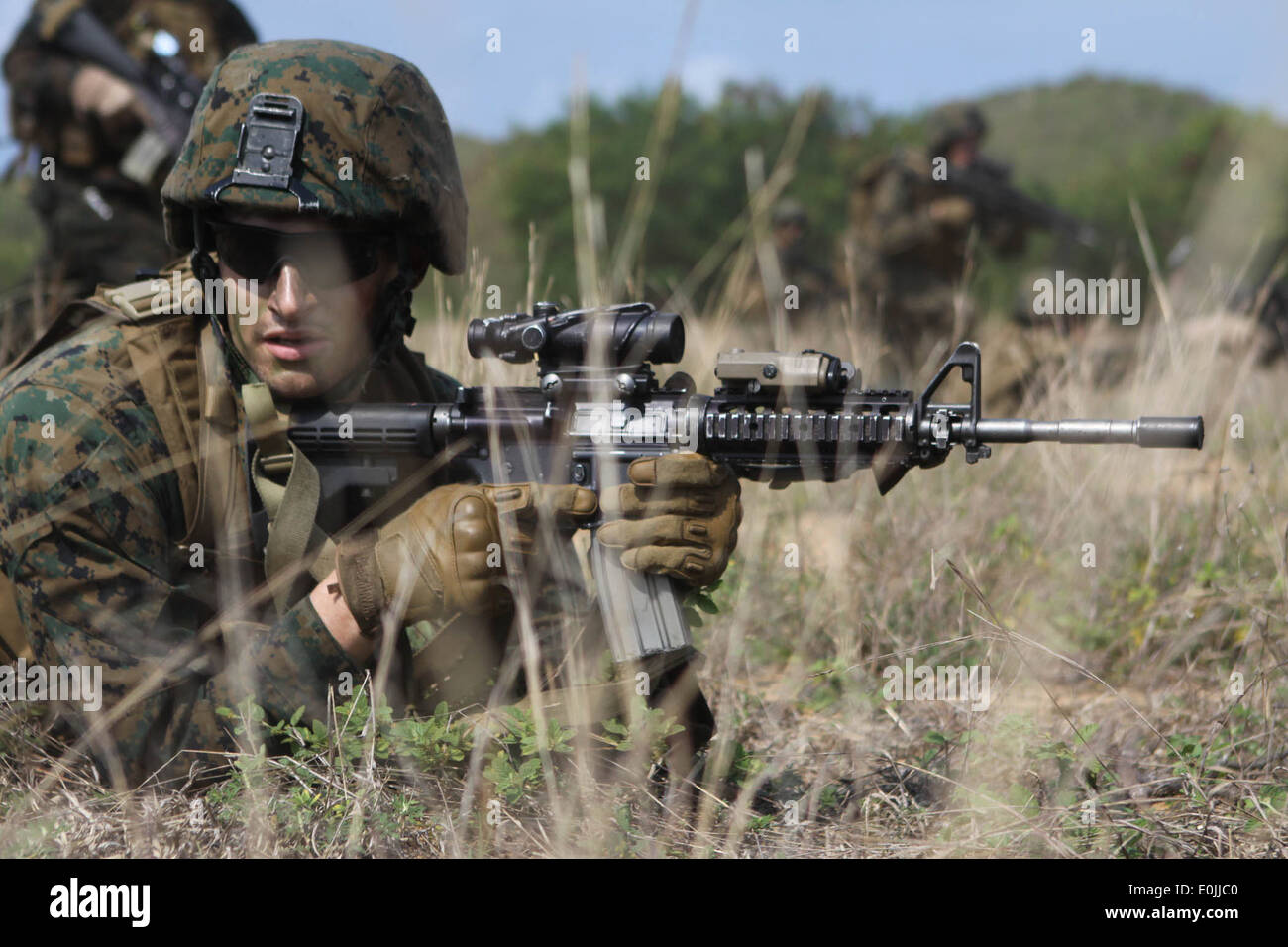 A U.S. Marine lays in the prone position during a mock amphibious assault conducted by the Marine and Naval forces of the Repub on of numerous military specialties, including air power, naval gunfire, naval transport, logistical planning, specialized equipment, land warfare, tactics and extensive training for all personnel involved. There are two main vehicles used in an amphibious assault; the Landing Craft Air Cushion and the Amphibious Assault Vehicle. (U.S. Marine Corps Photo by Cpl. Uriel De Luna-Felix/ Released) Stock Photo