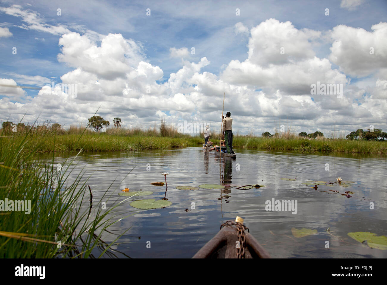 tourists on a traditional mokoro boat in the Okavango Delta, Botswana, Africa Stock Photo