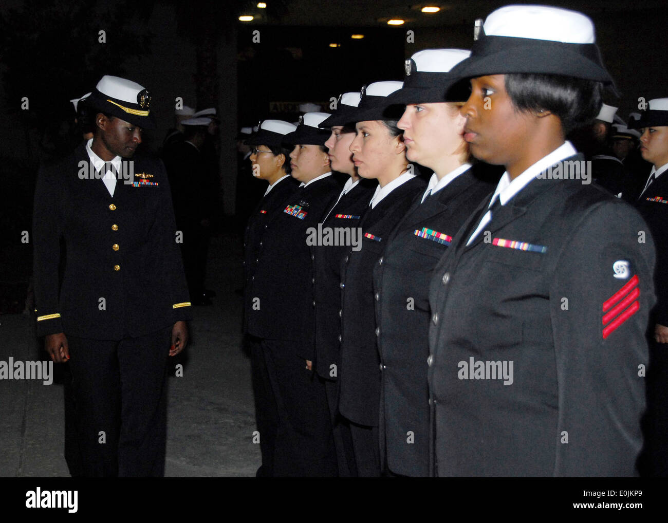 Ensign Ebony Miller inspects female Sailors during an early morning All Hands dress blues inspection for deck department aboard Stock Photo