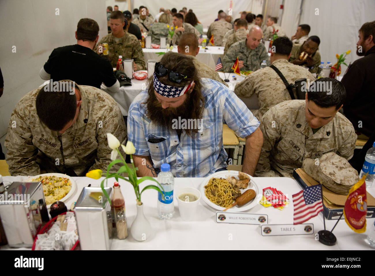 U.S. Marines with Regional Command (Southwest) pray with Willie Robertson, an actor, before a meal in the dining facility at Ca Stock Photo