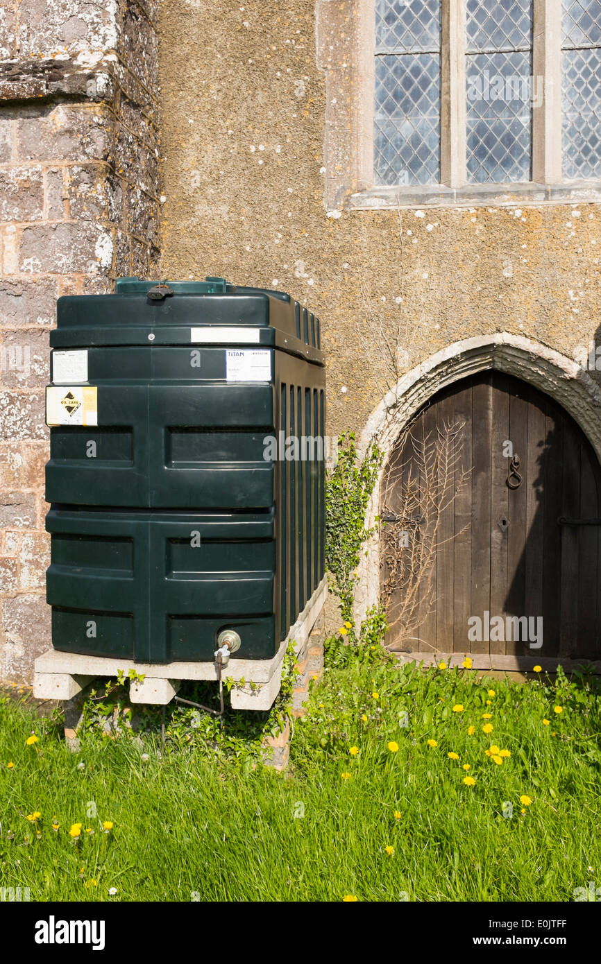 A heating oil tank, drum for storing oil at the back of St Matthew's Church, Cheriton Fitzpaine, Devon, United Kingdom Stock Photo