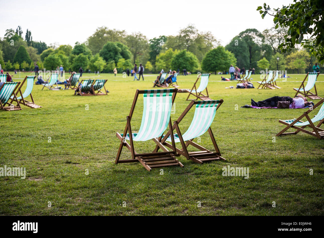 People sitting on deck chairs, Hyde Park, London, UK Stock Photo