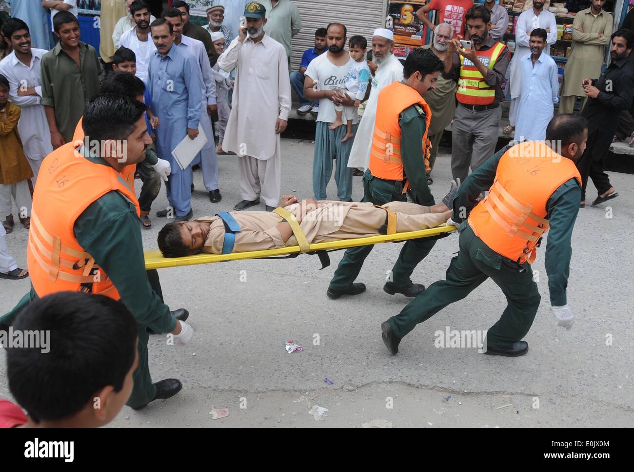 Rawalpindi, Pakistan. 15th May, 2014. Members of Pakistani rescuers and civil defence carry a mock injured victim on a stretcher a drill in Rawalpindi, Pakistan, May 15, 2014. Pakistani civil defence and rescuers attend a drill to prepare in case of flooding during the monsoon season which is due to start in June.  Credit:  M.Nadeem/Pacific Press/Alamy Live News Stock Photo