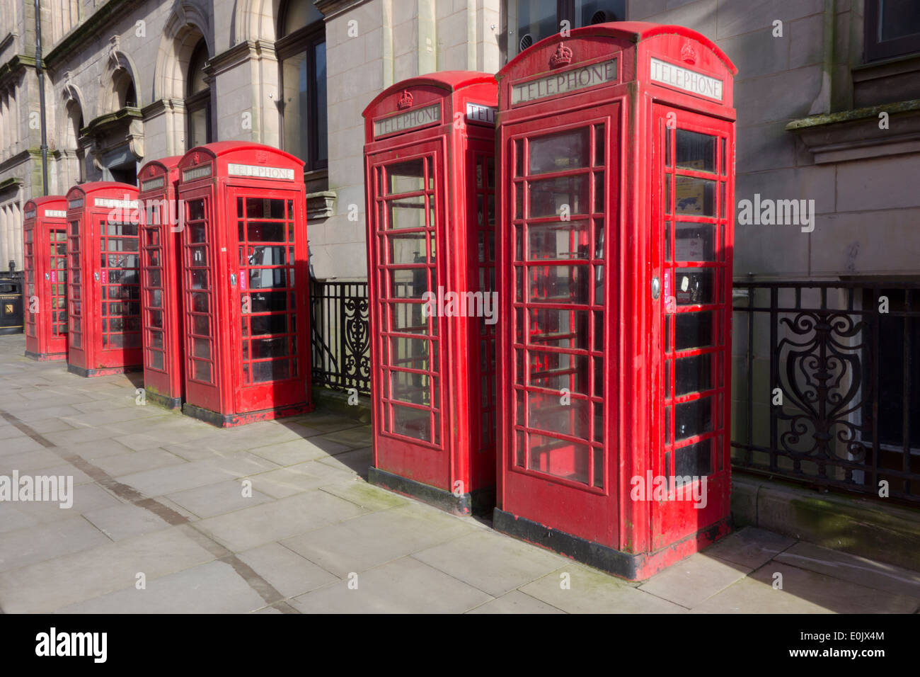 A row of 6 classic red British Telecom telephone boxes Stock Photo