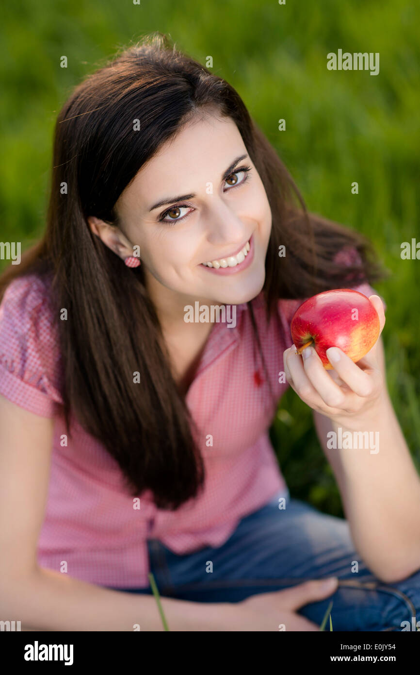 woman with apple in meadow, (Model release) Stock Photo