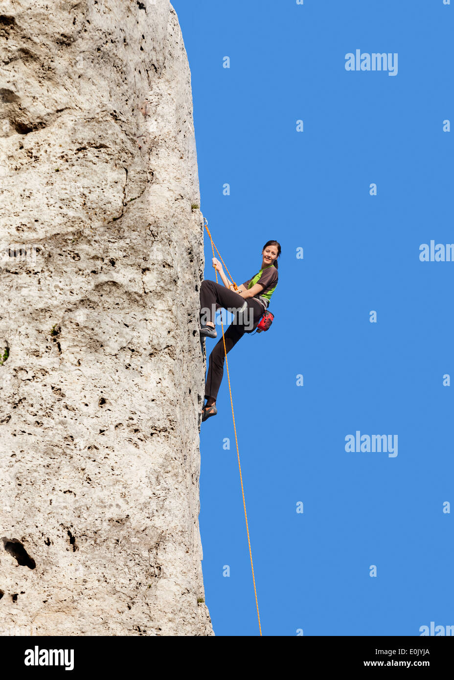 Happy woman climbing rock, active holidays. Stock Photo