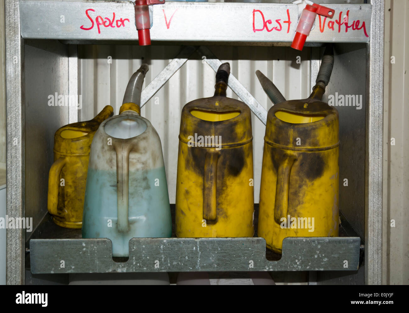 Greasy liquid cans with washer fluid and destilled water. Car mechanic ...