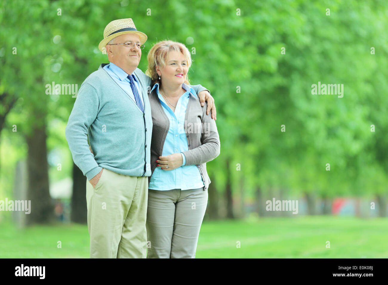 Mature couple standing in a park and looking at something Stock Photo