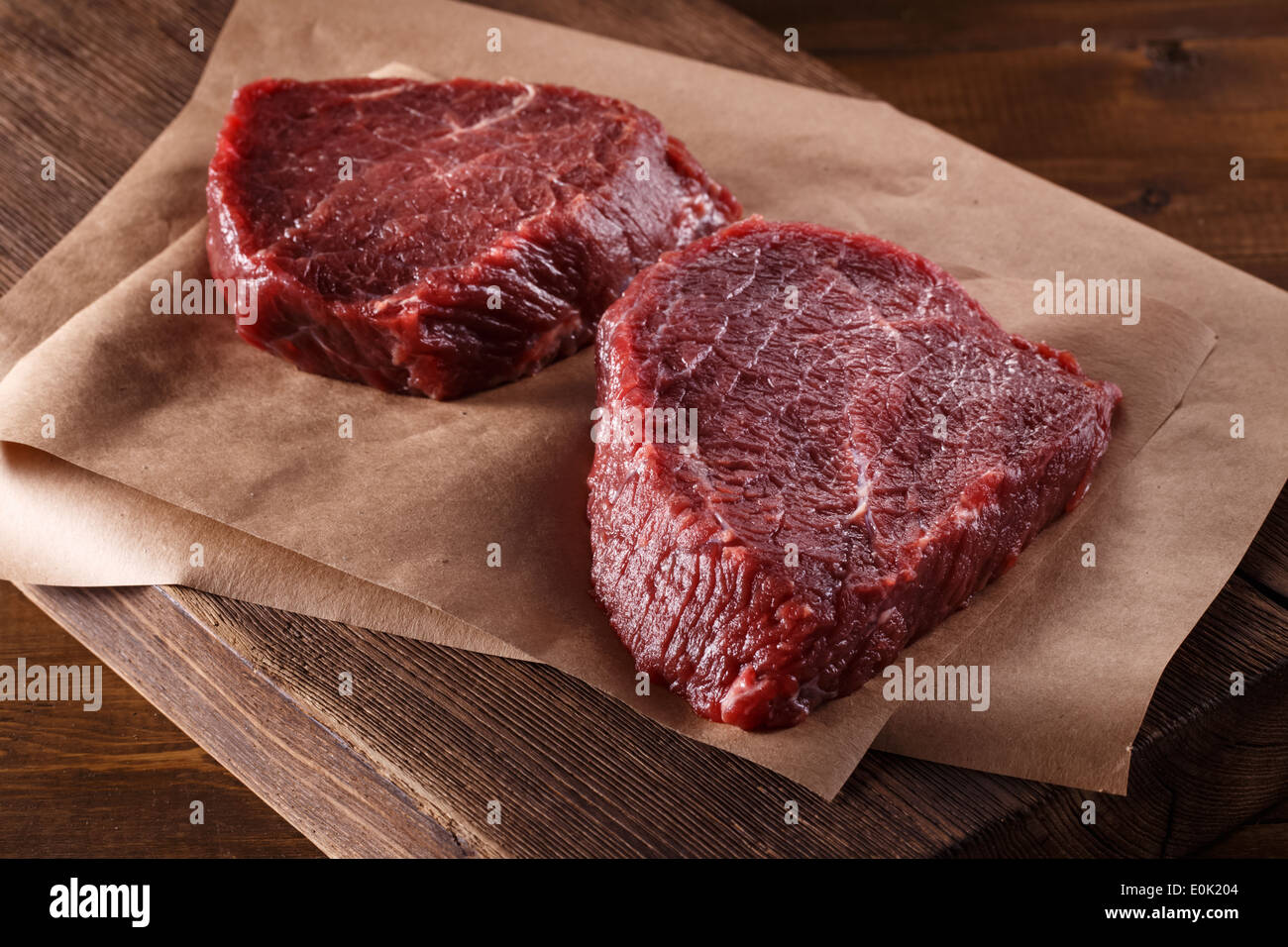 Succulent tender raw lean beef steaks lying on a sheet Stock Photo