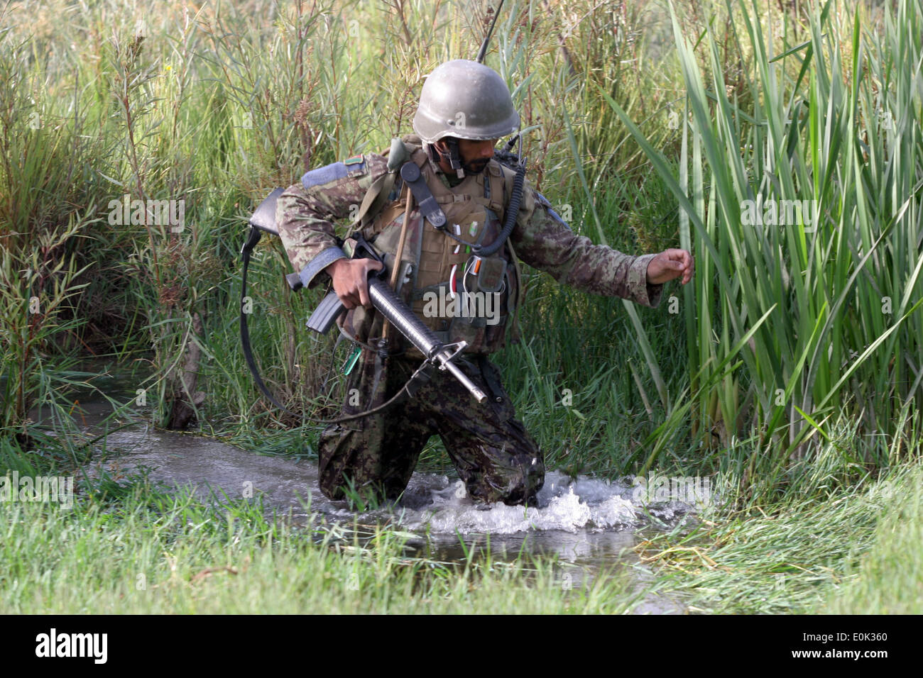 SANGIN, Helmand Province, Afghanistan - An Afghan soldier, of the 4th Tolay, 2nd Kandak, 215th Corps, sloshes through a canal w Stock Photo