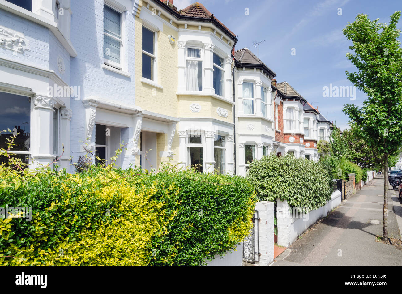 Residential street of two-storey terraced houses in the London district of Queens Park, London, England Stock Photo