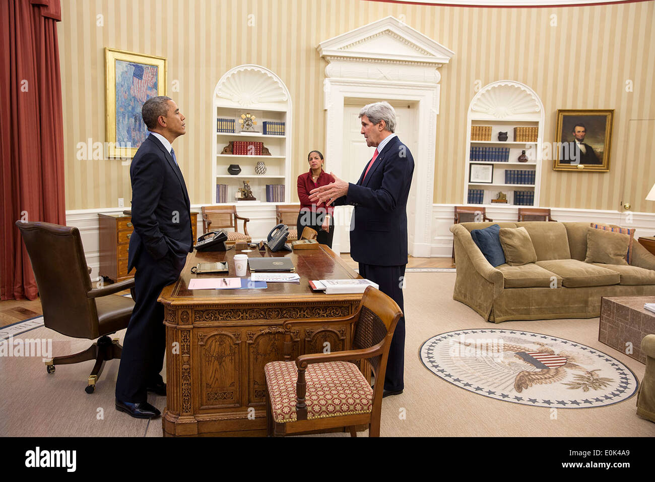 US President Barack Obama talks with Secretary of State John Kerry and National Security Advisor Susan E. Rice in the Oval Office of the White House March 19, 2014 in Washington, DC. Stock Photo