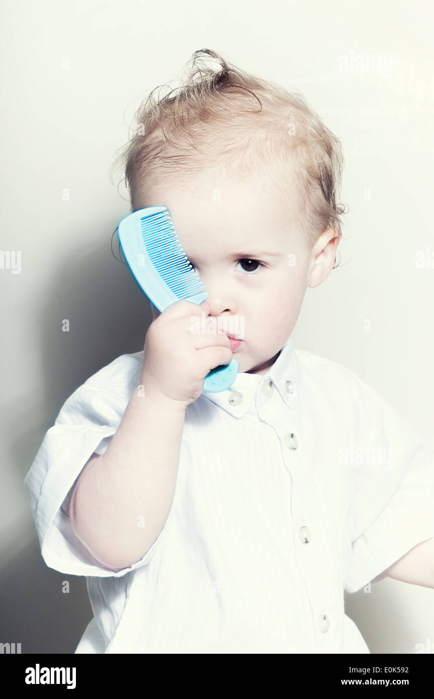 Cute Caucasian fifteen month old baby boy holding comb Stock Photo