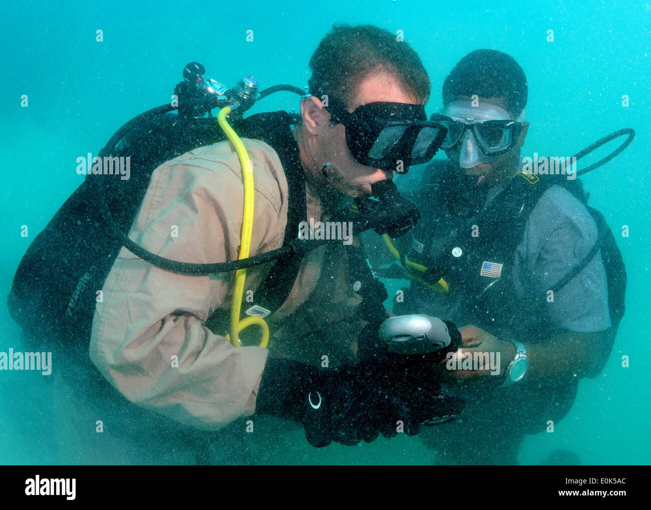 Construction Mechanic 2nd Class Aaron Heldreth checks bottle pressures with his buddy diver, Constable Gaveline Brouet, a Regio Stock Photo