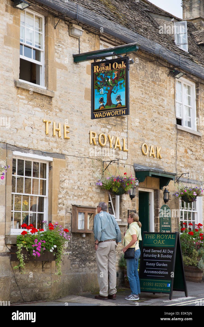 Tourist couple view food menu at The Royal Oak traditional old gastro pub hotel in Burford in The Cotswolds, Oxfordshire, UK Stock Photo
