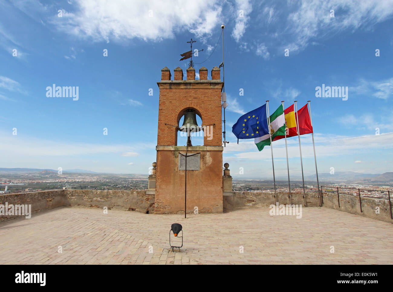 Flags and a crenelated bell tower at the highest point of the Alcazaba fortress of the Alhambra in Granada, Spain Stock Photo