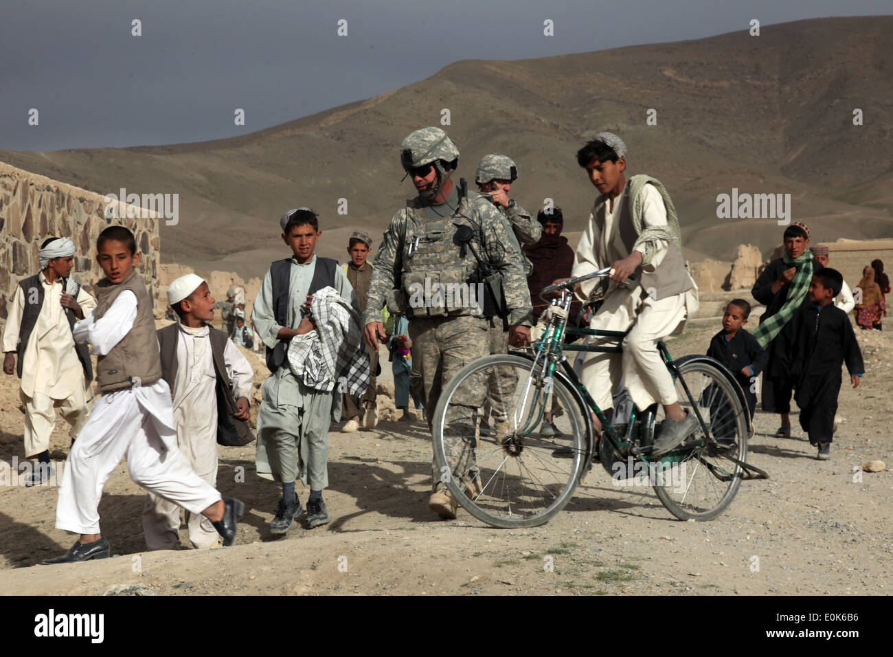 U.S. Army soldiers from the 450th Civil Affairs Battalion walk with Afghan children through the village of HeydarKheyl, Sayed-A Stock Photo