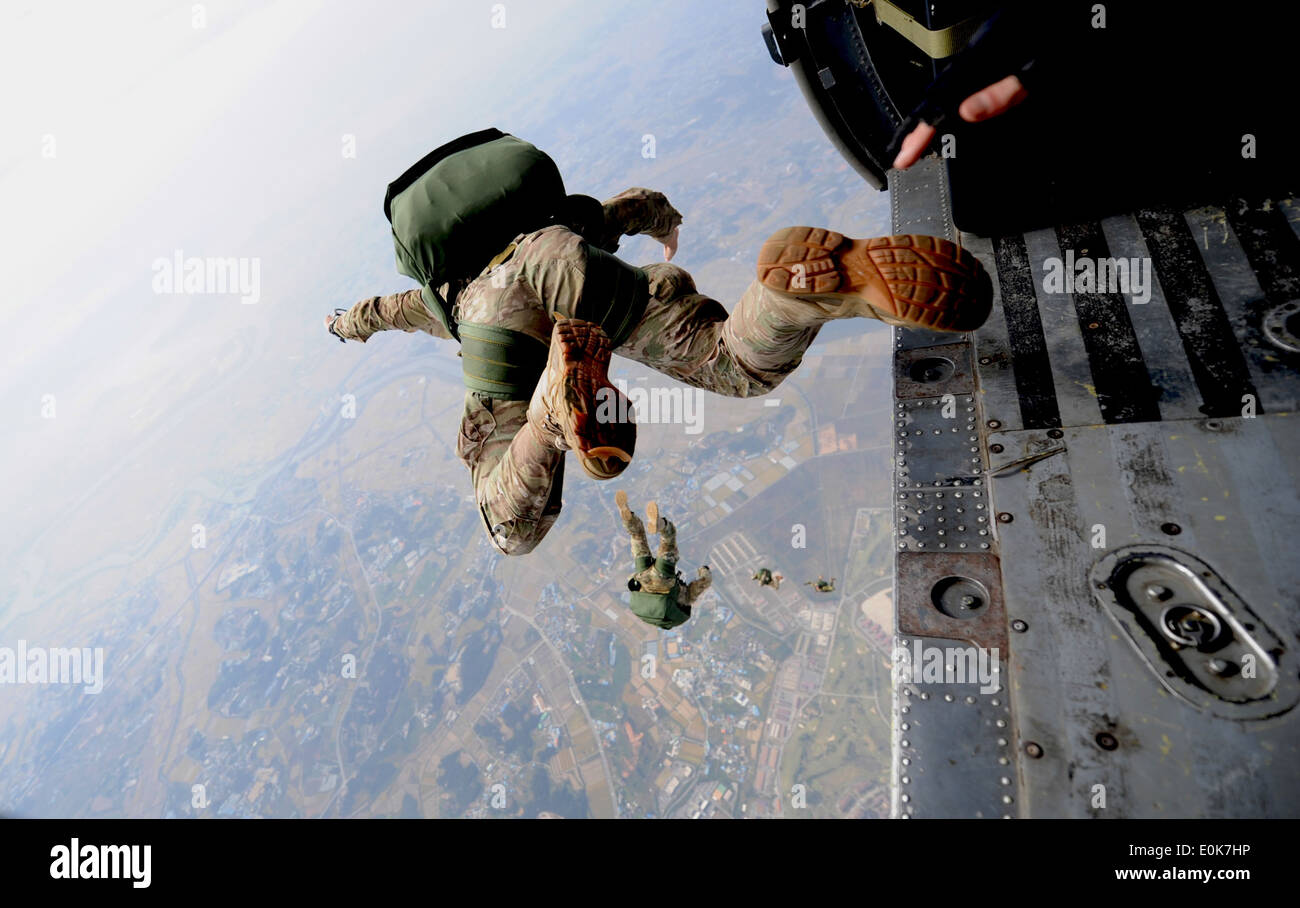 A pararescueman from the 31st Rescue Squadron freefalls with a parachute after jumping from a 33rd Rescue Squadron HH-60 Pave H Stock Photo