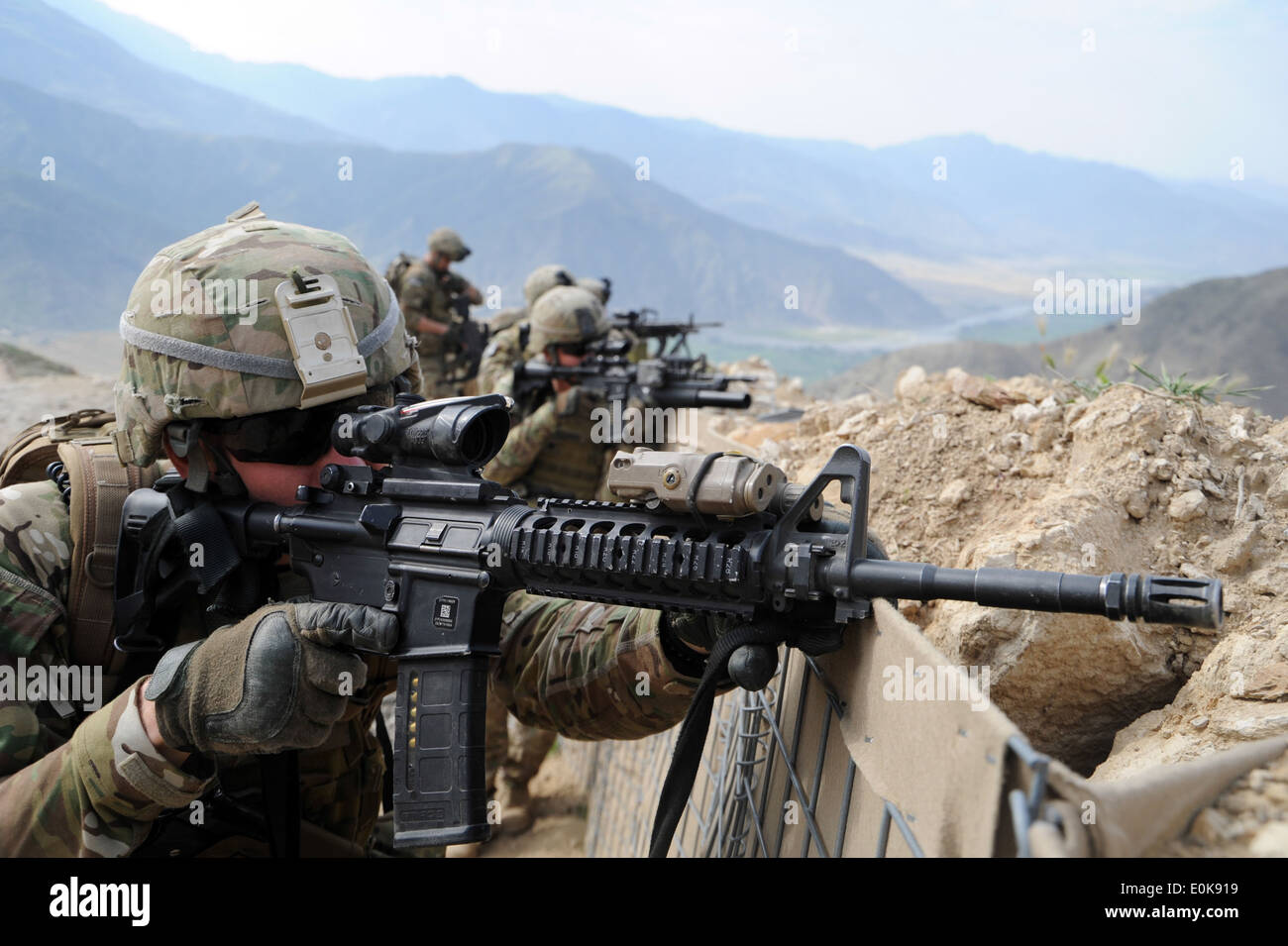 KUNAR PROVINCE, Afghanistan - U.S. Army National Guard Specialist Timothy Shout, a native of Austin, Texas, scans the nearby ri Stock Photo