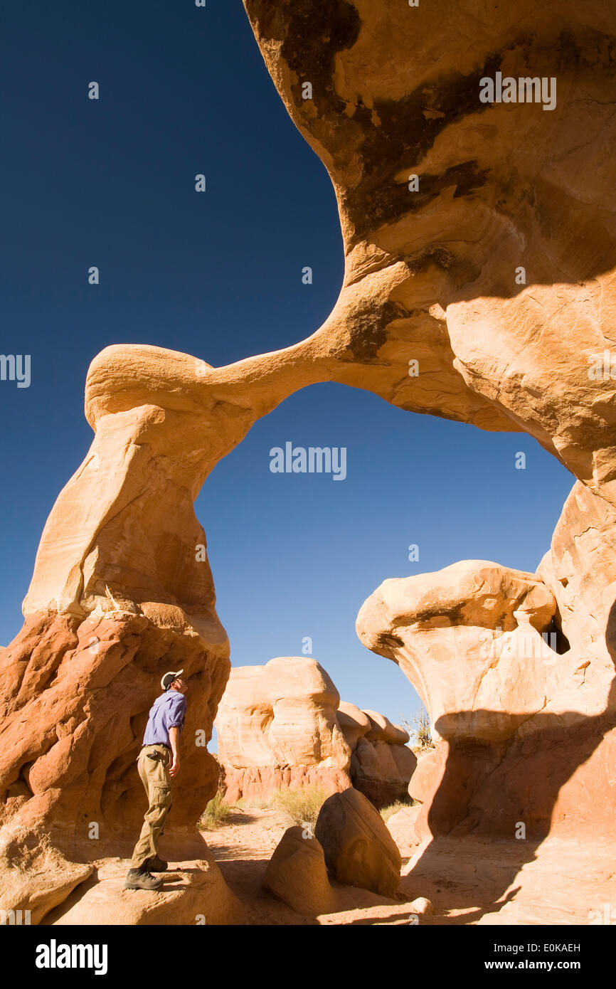 Hiker and Metate Arch, Devil's Garden, Grand Staircase-Escalante National Monument, Utah USA Stock Photo