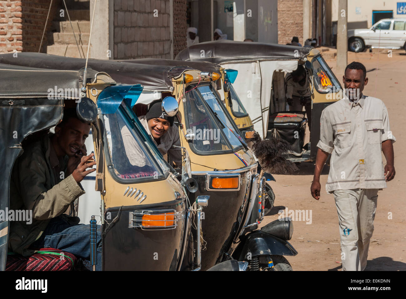 Auto Rickshaws (tuk-tuk taxi), drivers and pedestrian at taxi stand, Wadi Halfa, northern Sudan Stock Photo