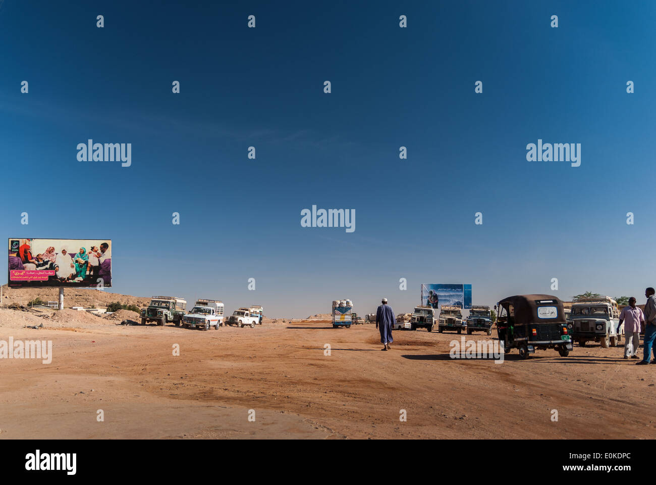 Exit from Wadi Halfa port, sandy track  to Wadi Halfa village and various taxis waiting for passengers, northern Sudan Stock Photo