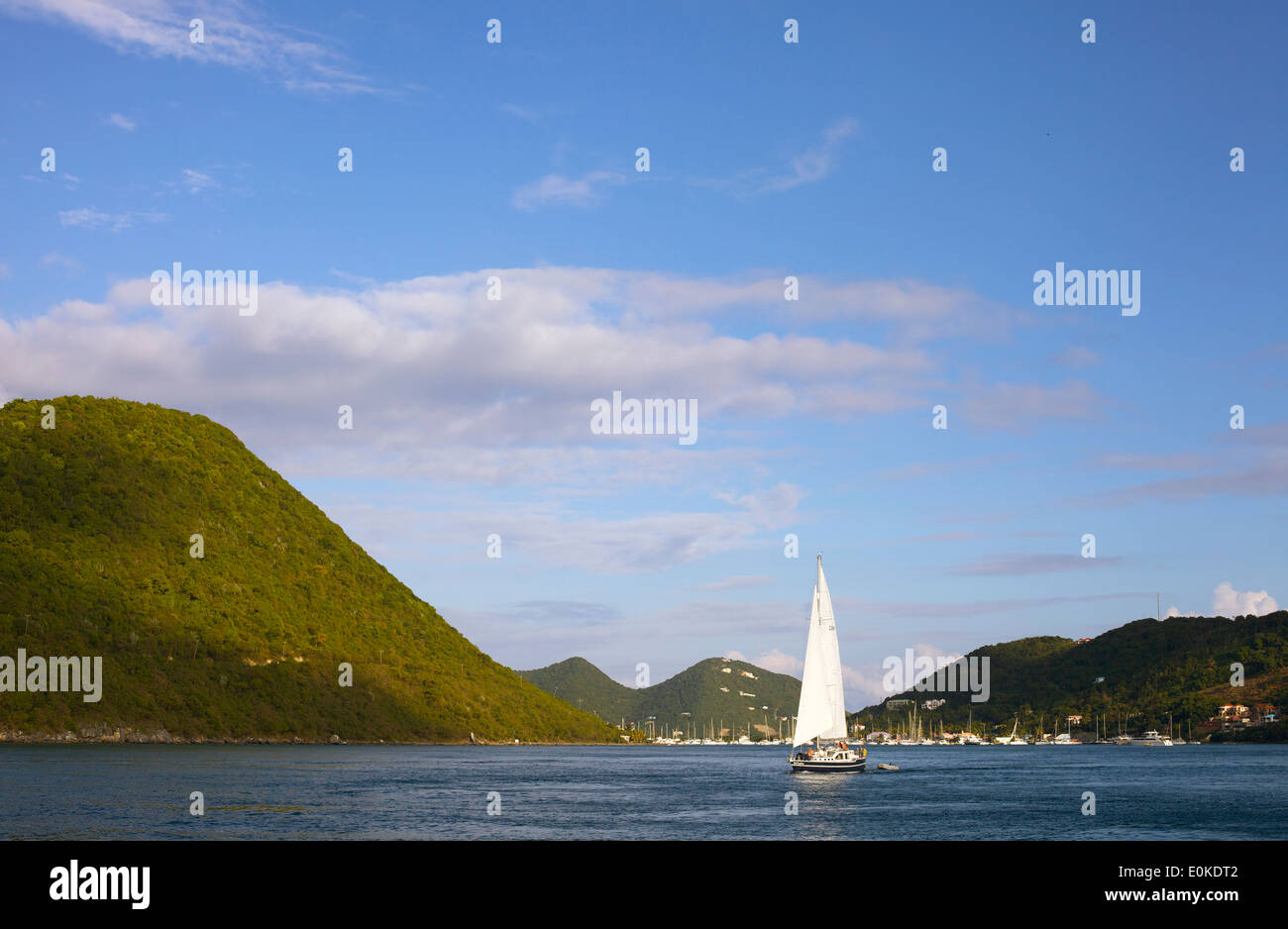 A sailboat cruises on the blue calm ocean in the British Virgin Islands. Stock Photo