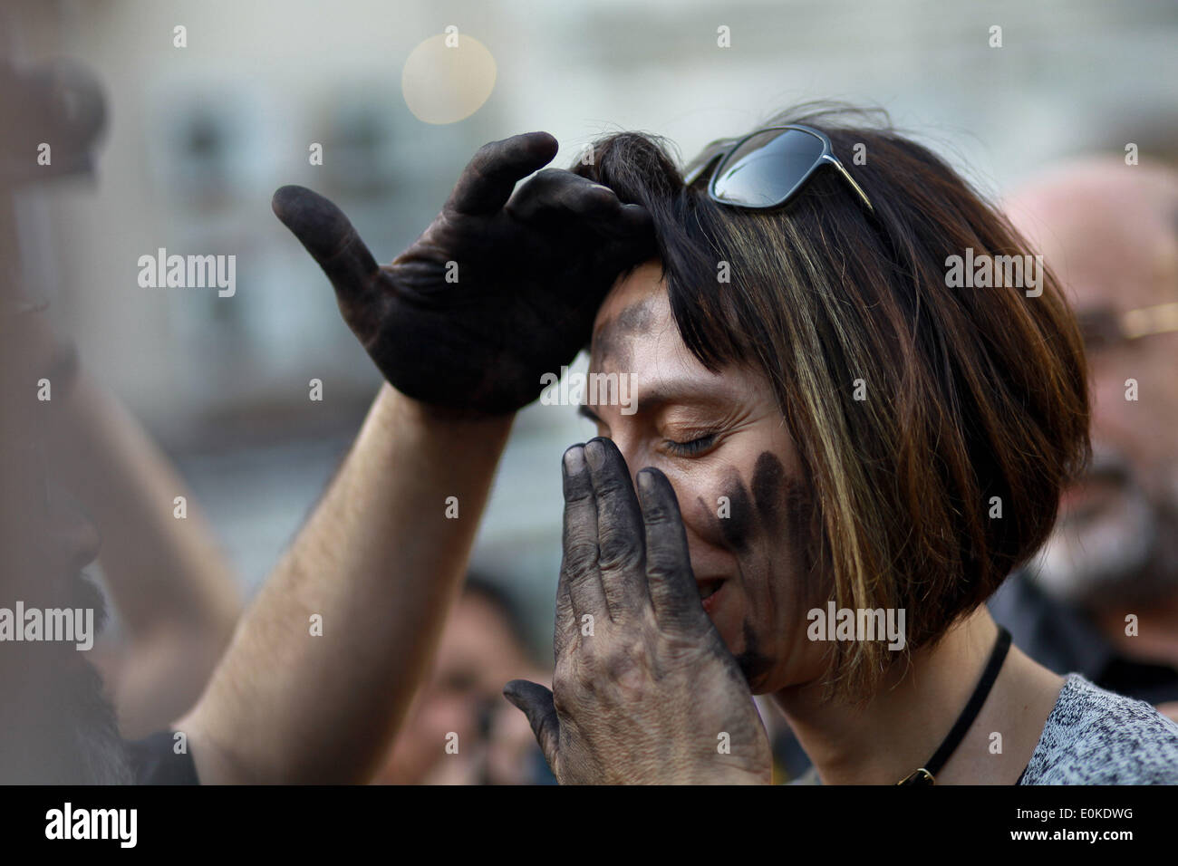 Istanbul, Turkey. 15th May, 2014. A Turkish activist stains face of a girl with coal during a protest in front of the Turkish policemen at a street near Taksim Square, in tribute to the victims of the Soma mine explosion, in Istanbul, Turkey, 15 May 2014. The corporate owner of the Soma coalmine, the scene of Turkey's worst mining disaster, said 450 workers had been saved and 80 of them were still in hospital. Credit:  Ahmed Deeb/NurPhoto/ZUMAPRESS.com/Alamy Live News Stock Photo