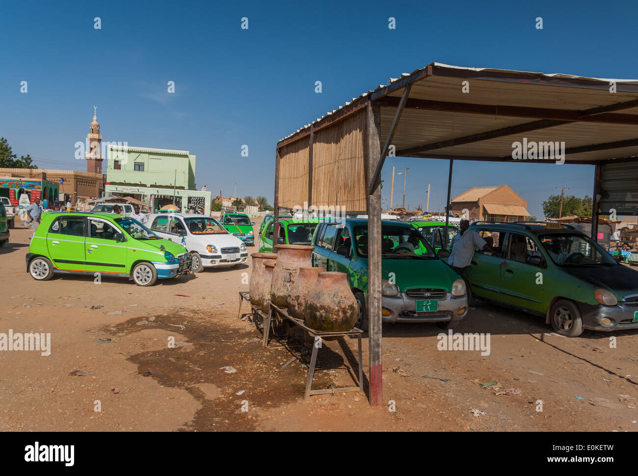 Green Hyundai taxis at filling (gas) station and zeers, (in centre of photograph), Karima, northern Sudan Stock Photo