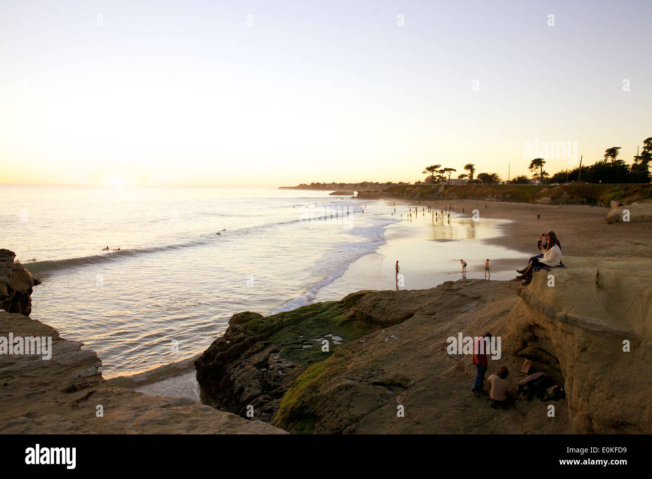 People hang out on the cliffs and take in the view as beach goers enjoy